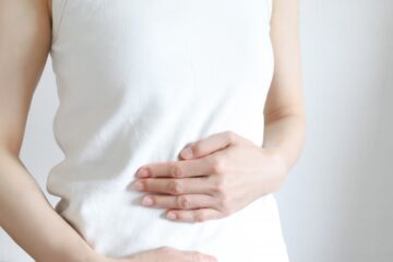 お腹の不調を感じる女性